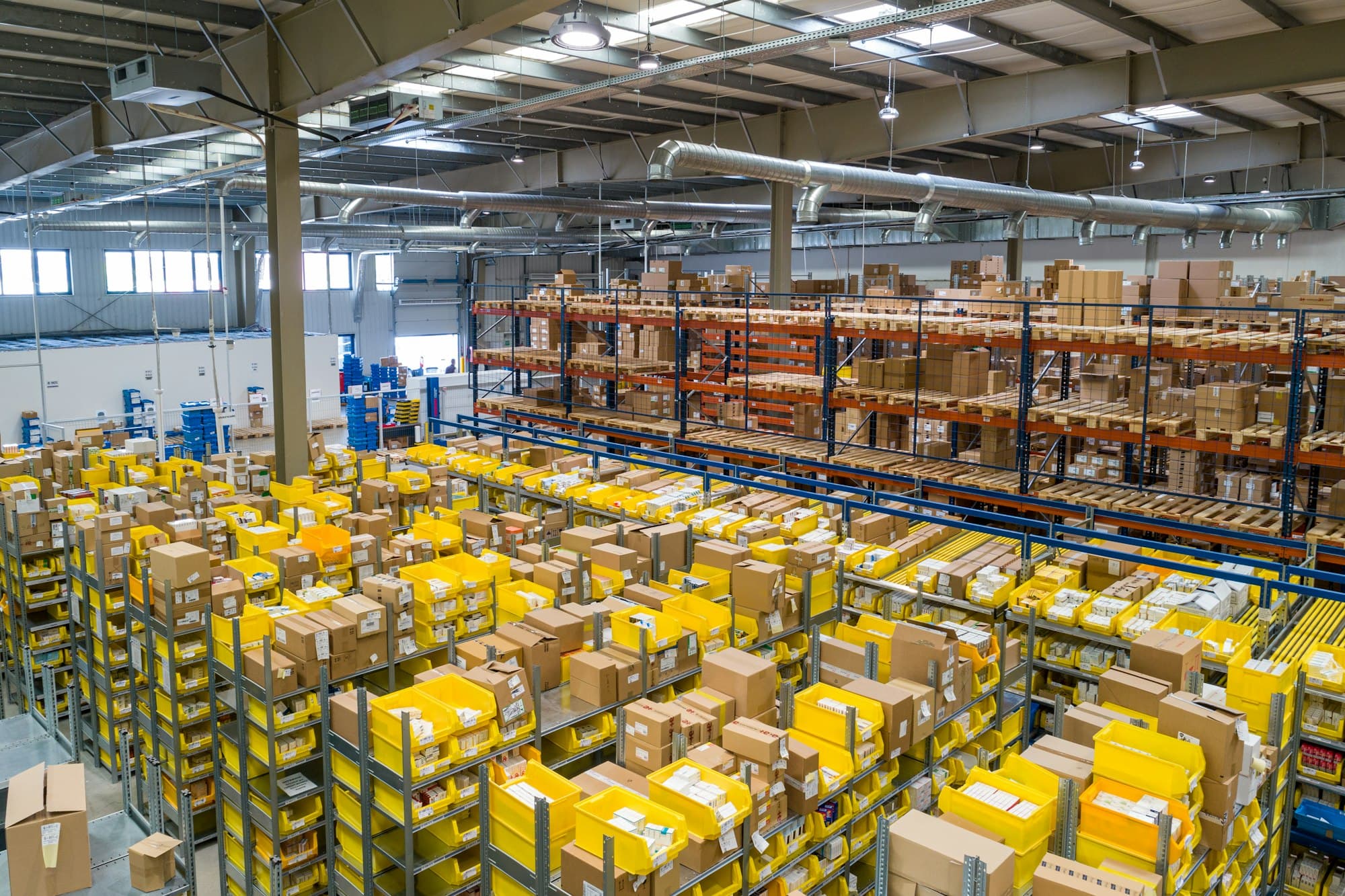 A large warehouse floor filled with shelving and stacked parcels