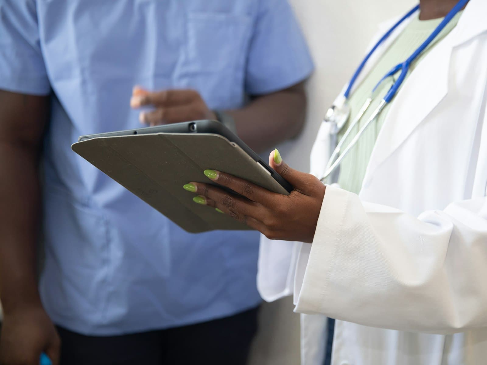 A doctor and a nurse reviewing a patient record on a tablet