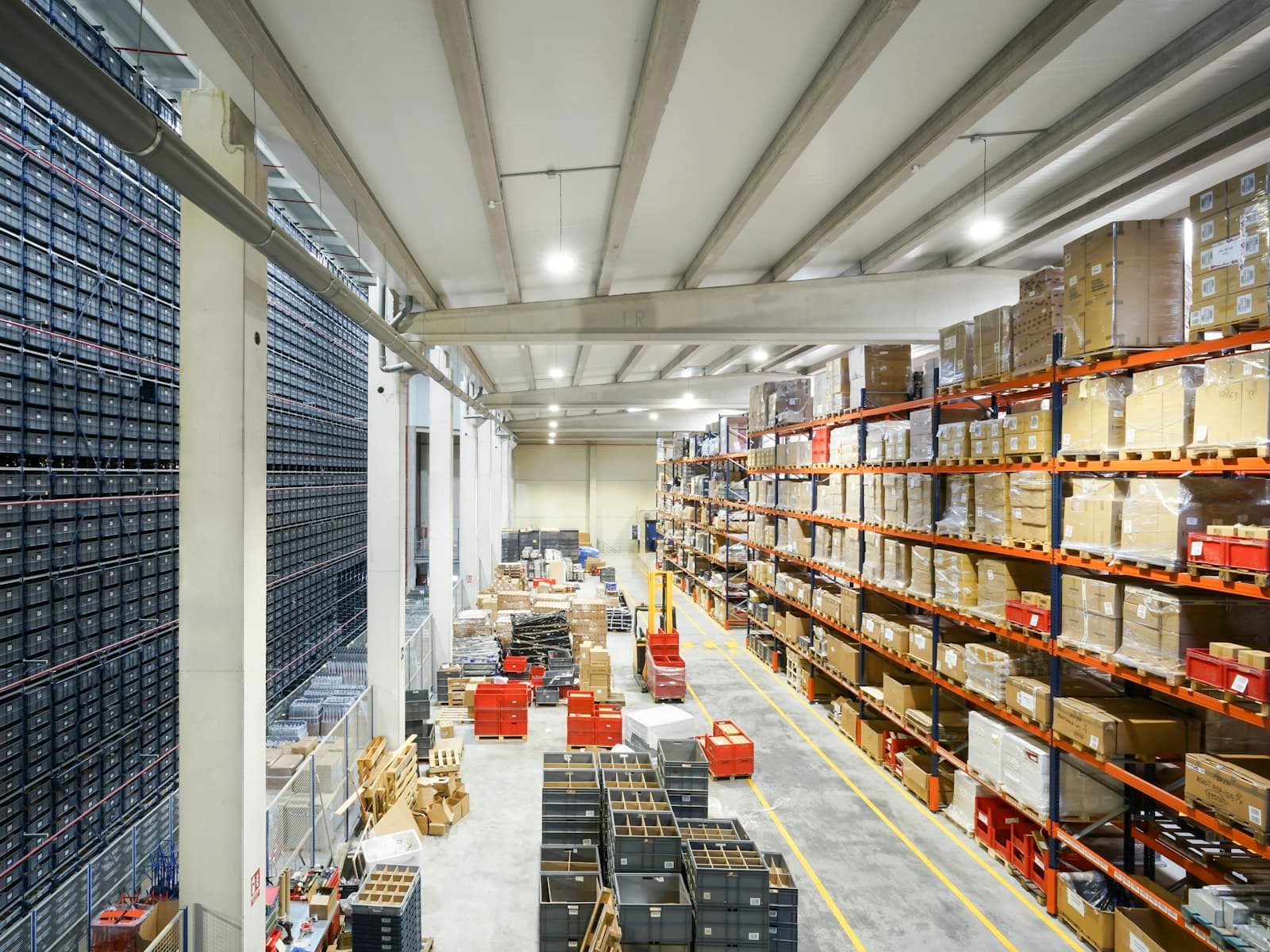 A warehouse aisle with stocked shelving and stacked crates