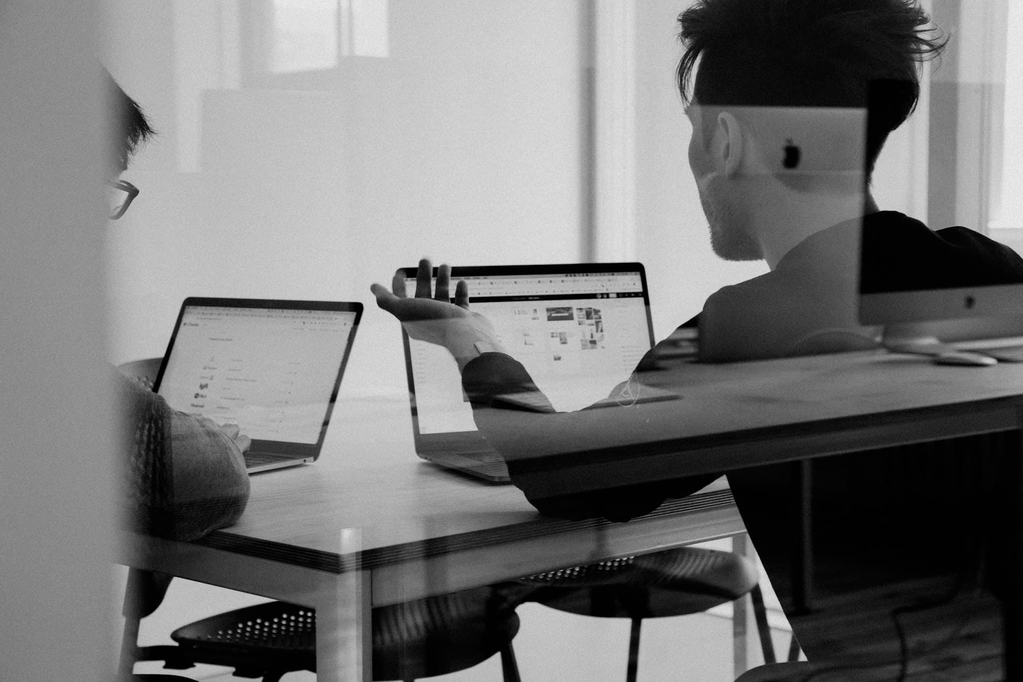 Colleagues reviewing work together on their laptops in a quiet office